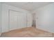 Bright bedroom featuring a double closet and neutral carpeting, ideal for comfort at 9701 Kent Village Dr, Charlotte, NC 28269