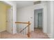 Well-lit hallway with wood railing leading to multiple rooms at 9701 Kent Village Dr, Charlotte, NC 28269