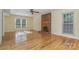 Sun-drenched living room features a brick fireplace, hardwood floors, and generous windows at 9701 Kent Village Dr, Charlotte, NC 28269