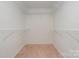 Spacious walk-in closet featuring carpeted floors and white shelving for optimal storage and organization at 9701 Kent Village Dr, Charlotte, NC 28269