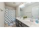 Bathroom featuring double sinks, a large mirror and a shower tub combination with a blue curtain at 1012 Leland Dr, Wesley Chapel, NC 28104