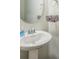 Bathroom featuring a pedestal sink, round mirror, and minimalist decor with a toilet paper holder at 1012 Leland Dr, Wesley Chapel, NC 28104