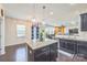 Open concept kitchen and dining area features dark cabinetry, granite countertops, and stainless steel appliances at 1012 Leland Dr, Wesley Chapel, NC 28104