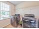 Laundry room with modern washer and dryer, tile flooring, and a window for natural light at 1012 Leland Dr, Wesley Chapel, NC 28104
