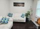 Cozy living room with white L-shaped sofa, throw pillows and modern decor with dark hardwood floors at 1012 Leland Dr, Wesley Chapel, NC 28104