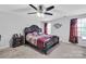 Spacious bedroom features a decorative headboard, ceiling fan, and large windows with stylish curtains at 1012 Leland Dr, Wesley Chapel, NC 28104