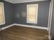 A light-filled bedroom with two windows, wood-look flooring, neutral gray walls, and white trim at 1110 20Th Ne St, Hickory, NC 28601