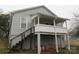 A home featuring a white, elevated porch and stairs to a partial basement at 1110 20Th Ne St, Hickory, NC 28601