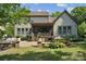 Landscaped backyard with a patio with grill, seating, and a screened in porch at 11412 Preservation Ln, Charlotte, NC 28278