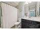 Well-lit bathroom featuring a shower with white curtain and dark vanity at 11412 Preservation Ln, Charlotte, NC 28278