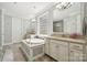 Luxurious bathroom with a soaking tub, separate vanities, and a glass block window for privacy at 11412 Preservation Ln, Charlotte, NC 28278