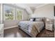 Bright bedroom featuring two large windows, a comfortable bed, and hardwood flooring at 11412 Preservation Ln, Charlotte, NC 28278