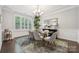 Elegant dining room featuring a glass table, shuttered windows, and a decorative mirror at 11412 Preservation Ln, Charlotte, NC 28278