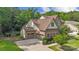 Aerial view of the home with three-car garage, nice lawn, and mature tree coverage at 11412 Preservation Ln, Charlotte, NC 28278