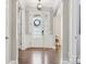 Bright foyer with a decorative front door, arched doorways, and wood flooring at 11412 Preservation Ln, Charlotte, NC 28278
