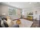 Bright living room with a cozy sofa, patterned rug, and entertainment area with a large window at 11412 Preservation Ln, Charlotte, NC 28278