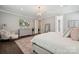 Well-lit primary bedroom with soft colors, a sitting area, and an ensuite bathroom access at 11412 Preservation Ln, Charlotte, NC 28278