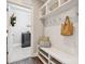 Well-organized mudroom with a bench, storage shelves, and hooks for coats and bags at 11412 Preservation Ln, Charlotte, NC 28278