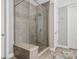 Modern bathroom featuring a glass-enclosed shower with tiled walls, bench, and dual shower heads at 11412 Preservation Ln, Charlotte, NC 28278
