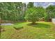 Lush backyard highlighting well-manicured lawn, mature trees, and a wooden fence, perfect for outdoor activities at 11539 Five Cedars Rd, Charlotte, NC 28226