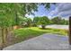 Spacious backyard featuring a grassy area, mature trees, wooden fence, and a concrete patio for outdoor enjoyment at 11539 Five Cedars Rd, Charlotte, NC 28226