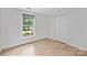 Simple bedroom with neutral walls, wood flooring, and a window, offering a clean and versatile space at 11539 Five Cedars Rd, Charlotte, NC 28226