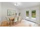 Bright dining room boasts a farmhouse table, neutral chairs, and glass doors to the outdoors at 11539 Five Cedars Rd, Charlotte, NC 28226