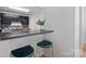 A breakfast bar with seating complements the black cabinets and modern tile backsplash in this kitchen at 11539 Five Cedars Rd, Charlotte, NC 28226