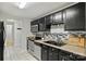 Modern kitchen featuring black cabinets, stainless appliances, mosaic backsplash and neutral countertops at 11539 Five Cedars Rd, Charlotte, NC 28226