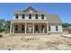 Charming two-story home with brick veneer, a covered porch, white columns, and complementary siding at 11543 Valley Oak Ln, Stanfield, NC 28163