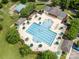 Aerial view of a community pool area with lounge chairs, umbrellas, and mature trees at 12342 Carrigan Ct, Huntersville, NC 28078