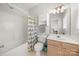 Well-lit bathroom with a vanity, toilet, and shower with colorful curtain at 12342 Carrigan Ct, Huntersville, NC 28078