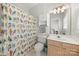 Cheerful bathroom featuring a vanity with bright cabinet, toilet, and shower with colorful curtain at 12342 Carrigan Ct, Huntersville, NC 28078