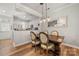 Dining room with wood table and chairs, modern lighting, hardwood floors, and kitchen access at 12342 Carrigan Ct, Huntersville, NC 28078