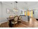 Open concept dining area with wooden table, modern light fixture, living room and kitchen access at 12342 Carrigan Ct, Huntersville, NC 28078
