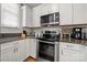 Modern kitchen featuring stainless steel appliances, white cabinets, and dark granite countertops at 12342 Carrigan Ct, Huntersville, NC 28078