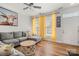 Comfortable living room featuring hardwood floors, large sofa, and bright yellow curtains at 12342 Carrigan Ct, Huntersville, NC 28078