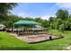 Community playground featuring multiple play structures, shade, and mature trees at 12342 Carrigan Ct, Huntersville, NC 28078