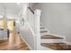 Bright hallway with hardwood floors and a white staircase at 12342 Carrigan Ct, Huntersville, NC 28078