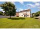 Expansive fenced backyard with lush green lawn, mature tree, and patio perfect for outdoor living at 124 Glade Valley Ave, Mooresville, NC 28117