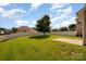 Spacious fenced backyard features a lush green lawn, mature tree, and a concrete patio at 124 Glade Valley Ave, Mooresville, NC 28117