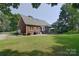 Brick home with a well-maintained lawn and a stone patio with outdoor seating at 14232 Kendalton Meadow Dr, Mint Hill, NC 28227