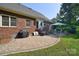 Brick home features a paved patio with seating area, grill, and well-manicured lawn at 14232 Kendalton Meadow Dr, Mint Hill, NC 28227
