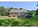 View of the brick home's back exterior, featuring a paved patio and green lawn at 14232 Kendalton Meadow Dr, Mint Hill, NC 28227