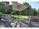 Backyard brick patio with umbrella and chairs with backyard in the background at 14232 Kendalton Meadow Dr, Mint Hill, NC 28227