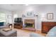 Cozy living room with a classic brick fireplace, hardwood floors, and neutral decor at 14232 Kendalton Meadow Dr, Mint Hill, NC 28227