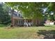 Traditional brick home with a well-maintained lawn and inviting front porch framed by mature trees at 14232 Kendalton Meadow Dr, Mint Hill, NC 28227