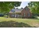 Charming single-Gathering home with a well-manicured lawn, inviting front porch, and traditional brick facade at 14232 Kendalton Meadow Dr, Mint Hill, NC 28227