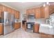 Spacious kitchen featuring stainless steel appliances, tile floors, and wooden cabinets at 14232 Kendalton Meadow Dr, Mint Hill, NC 28227
