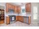Bright kitchen featuring stainless steel appliances, tile floors, and wooden cabinets at 14232 Kendalton Meadow Dr, Mint Hill, NC 28227